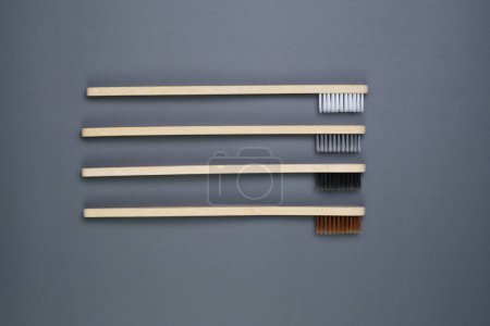 Téléchargez les photos : Un groupe de trois brosses à dents posées sur une table en bois, prêtes à l'emploi dans la routine d'hygiène buccodentaire. - en image libre de droit