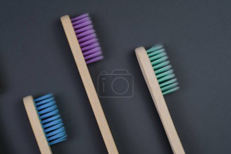 Téléchargez les photos : Trois brosses à dents de différentes couleurs et tailles sont soigneusement placées l'une à côté de l'autre sur une table, prêtes à l'emploi. - en image libre de droit