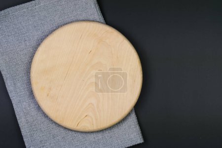 A wooden plate is placed on top of a cloth, creating a simple and practical setting.