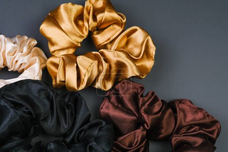 Photo for Three scrunchies of different colors - pink, blue, and yellow - are arranged neatly on a gray background, creating a visually appealing contrast. - Royalty Free Image