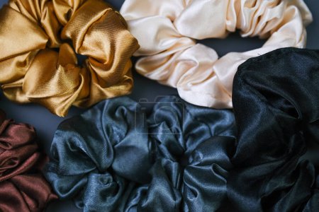 Photo for A variety of different colored scrunchies are neatly arranged on top of a wooden table, showcasing their vibrant hues and textures. - Royalty Free Image