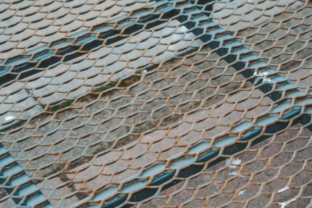 Téléchargez les photos : Gros plan détaillé d'une clôture en treillis métallique, mettant en valeur les motifs et la structure complexes du matériau de clôture. - en image libre de droit