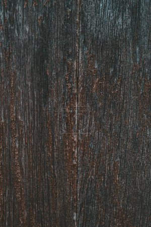 Une vue détaillée d'une surface en bois avec des taches de rouille, montrant les effets de l'altération et de l'oxydation au fil du temps.