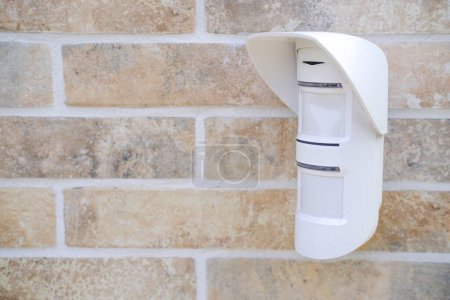 A white wall mounted mailbox securely attached to a brick wall, providing a functional and practical solution for mail delivery and collection outdoors.