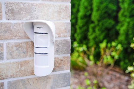 A white wall mounted mailbox is affixed to a brick wall, providing a functional and convenient place for mail delivery and collection.