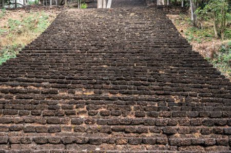 The stairway made of laterite blocks leads to the top of Wat Khao Phanom Phloeng temple located near the Yom river in the central zone of the Si Satchanalai Historical Park.
