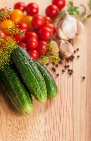 Photo for Fresh cucumbers, tomatoes of cherry and fennel branch on a kitchen board - Royalty Free Image