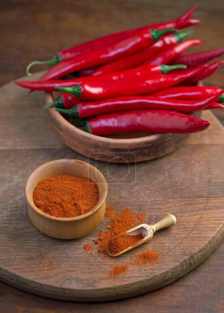 Foto de Fresh red chili peppers on wooden board - chili background - Imagen libre de derechos
