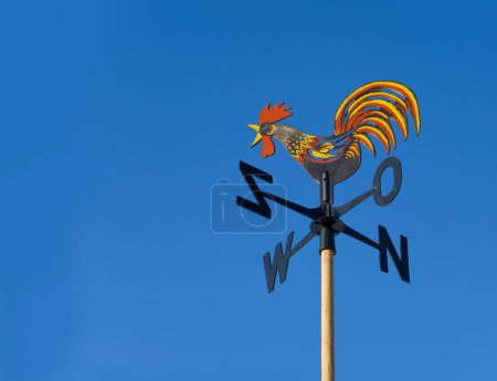 Photo for Wind vane to indicate the wind direction and the metal cock above the arrow and cardinal points North East South West. - Royalty Free Image