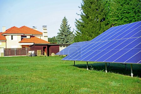 Eco-friendly solar panels installed on a green lawn in a residential area, showcasing a commitment to renewable energy and sustainable living.