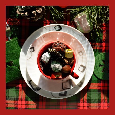 Téléchargez les photos : Tasse rouge remplie de divers bonbons sur des plaques blanches, vue de dessus - en image libre de droit