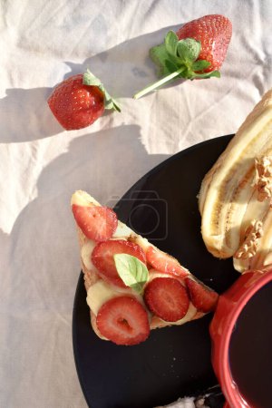Photo for Fruit sandwiches on black plate decorated by strawberry, top view - Royalty Free Image