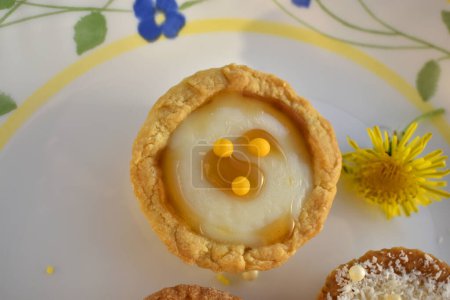 Mini tart filled with buttercream on a plate, top view