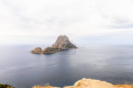 Foto de Islas características de Es Vedra y Es Vedranell frente a la costa sur de Ibiza, vistas desde la meseta Mirador des Vedra, en un día nublado. Las islas son muy reconocibles, y son sinónimo de Ibiza, y considerado un hito de Ibiza - Imagen libre de derechos