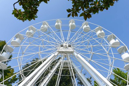 The beautiful all white ferris wheel in the harbour of Bardolino, in lake Garda, Veneto, Italy. The ferris wheel is seen up close from the ground and up. It is a beautiful sunny autumn day