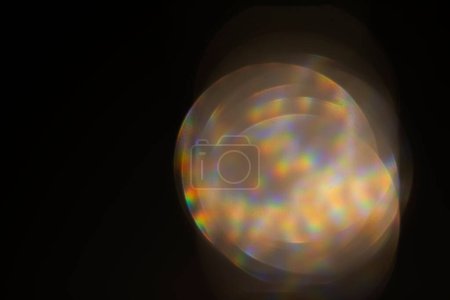 Foto de Efecto deslumbrante sobre un fondo negro. Una llamarada de lente abstracta para uso en pantalla. Deslumbramiento de los rayos ópticos de la lente. - Imagen libre de derechos