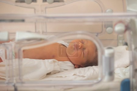 Neonatology. A newborn in a special incubator for babies in a hospital.