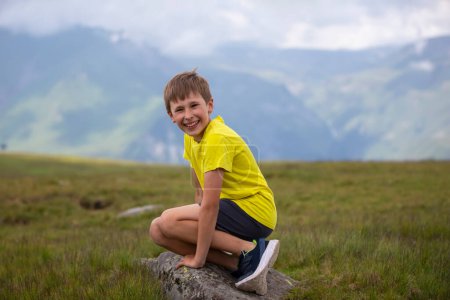 Photo for Happy boy on the background of a mountain landscape, looking at the camera and smiling - Royalty Free Image