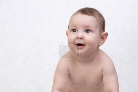 Six month old baby on a white background. Happy boy mid-range. Conceptual photo of fatherhood and motherhood.Alpha generation.