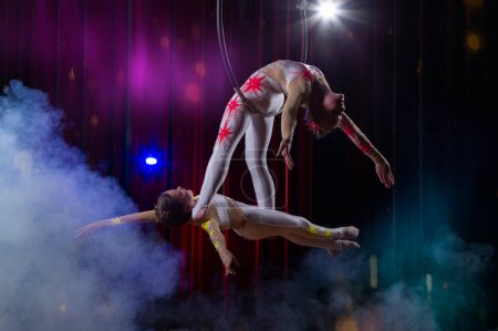 Photo for Circus acrobats gymnasts perform on a stage dark background. - Royalty Free Image