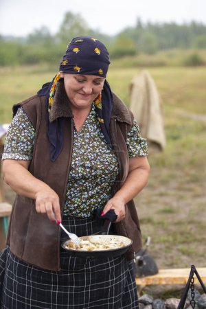 Téléchargez les photos : Biélorussie, région de Gomel, 20 juillet 2022. Camp de réfugiés. Une réfugiée prépare à manger. - en image libre de droit