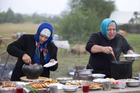 Téléchargez les photos : Biélorussie, région de Gomel, 20 juillet 2022. Camp de réfugiés. Des femmes réfugiées préparent de la nourriture à l'extérieur dans un camp de réfugiés. - en image libre de droit
