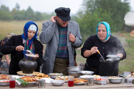 Téléchargez les photos : Biélorussie, région de Gomel, 20 juillet 2022. Camp de réfugiés. Femmes et hommes réfugiés préparent leur nourriture à l'extérieur dans un camp de réfugiés. - en image libre de droit