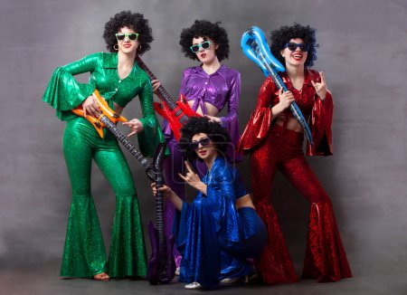 Photo for Group of girls in disco style with toy guitars. Vintage disco group for women. - Royalty Free Image