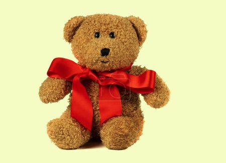 Photo for Toy fluffy vintage bear with a red bow on a retro background. Children's cute soft toy. - Royalty Free Image