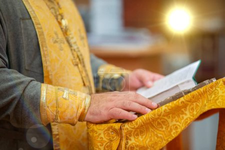 Die Hände eines orthodoxen Priesters halten eine Bibel