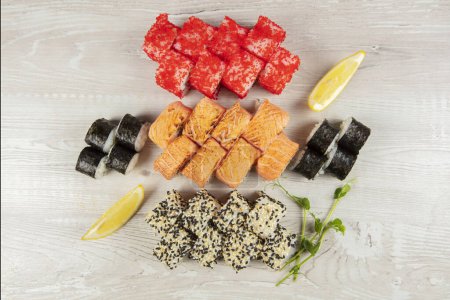 Téléchargez les photos : Ensemble de différents rouleaux de sushi sur un fond blanc en bois close-up. - en image libre de droit