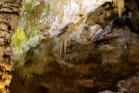 Die Höhle ist Karst, atemberaubende Aussicht auf Stalaktiten und Stalagniten, die von hellem Licht erhellt werden, eine wunderschöne natürliche Attraktion in einem Touristenort.