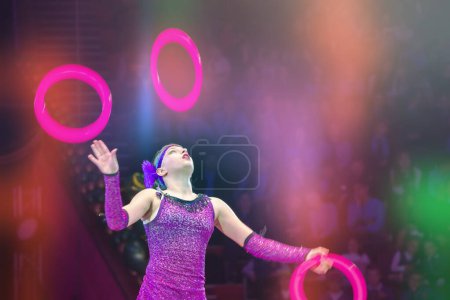 Foto de Belarús, Gomel, 1 de abril de 2018. Gomel State Circus.Una chica de circo hace malabares con anillos, actúa en la arena del circo. - Imagen libre de derechos