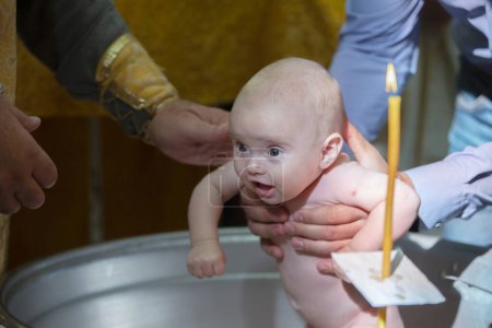 Bautismo ortodoxo de un bebé. Bañar a un bebé en una fuente de la iglesia al aceptar la fe.