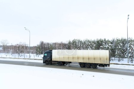 Foto de Un camión semirremolque, semirremolque, unidad tractora y semirremolque para transportar mercancías. Transporte de carga en duras condiciones de invierno en carreteras resbaladizas, heladas y nevadas. - Imagen libre de derechos