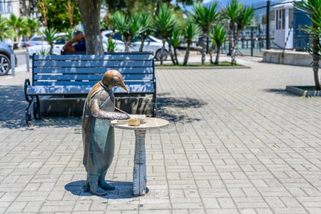 Suchumi, Abchasien, Georgien - 03. Juli 2022: Skulptur eines Pinguins mit Tintenfass und Buch am Wasser.