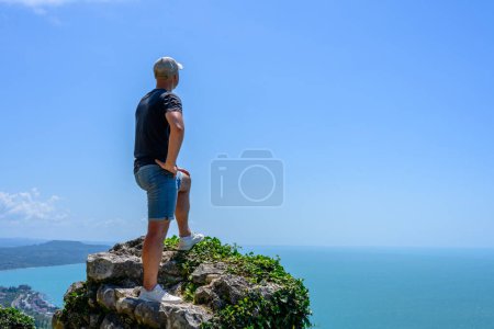 Man on the background of the Black sea and the city of New Athos in the Republic of Abkhazia