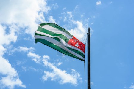 Abhkazia-Flagge weht im Wind, blauer Himmel Hintergrund
