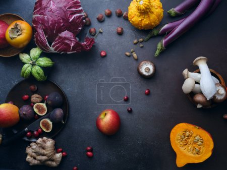 Foto de Top view seasonal groceries, healthy vegetarian ingredients for cooking a dinner on a dark background - Imagen libre de derechos