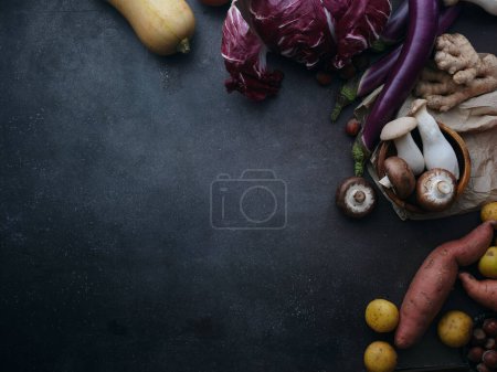 Foto de Top view seasonal groceries, healthy vegetarian ingredients for cooking a dinner on a dark background - Imagen libre de derechos
