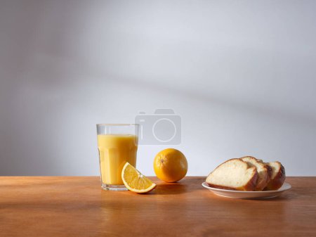 Photo for Breakfast with a glass of fresh-pressed orange juice and some slices of brioche bread - Royalty Free Image