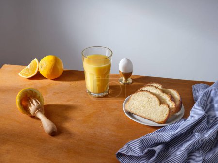 Foto de Breakfast with a glass of fresh-pressed orange juice and some slices of brioche bread - Imagen libre de derechos
