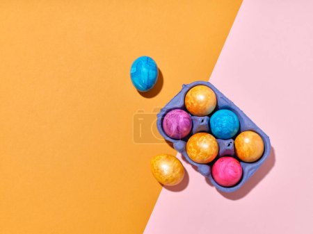 Foto de Top view layout with colored easter eggs on bright background. Creative template for festive content - Imagen libre de derechos