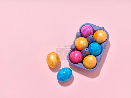 Foto de Top view layout with colored easter eggs on pink background. Creative template for festive content - Imagen libre de derechos