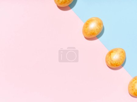 Foto de Diseño creativo con huevos de Pascua dorados de colores sobre fondo azul brillante y rosa. Concepto de imágenes festivas - Imagen libre de derechos