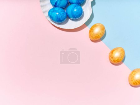 Foto de Creative layout with colored easter eggs arranged in a seashell on bright blue and pink background. A template for festive content - Imagen libre de derechos