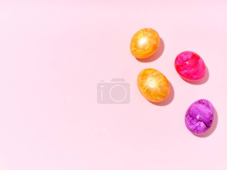 Foto de Creative layout with colored red and golden easter eggs on bright pink background. A template for festive content - Imagen libre de derechos
