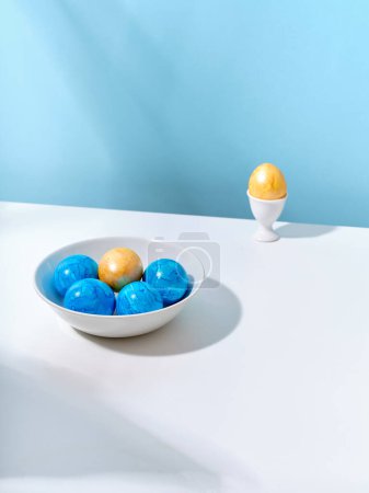 Foto de Diseño creativo con huevos de Pascua de color azul y dorado sobre fondo brillante. Una plantilla para contenido festivo - Imagen libre de derechos