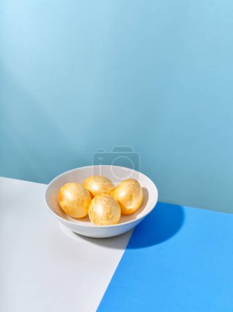 Téléchargez les photos : Creative layout with colored blue and golden easter eggs on bright background. A template for festive content - en image libre de droit