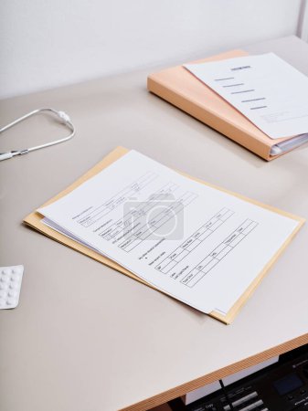 Téléchargez les photos : Par-dessus la paperasse médicale allongée sur la table du médecin - en image libre de droit